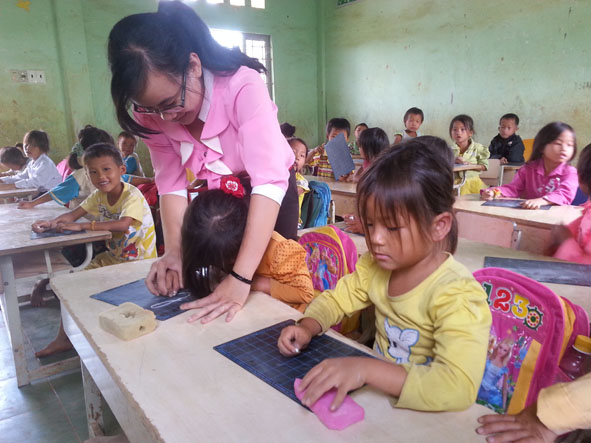 Cô giáo Nguyễn Thị Mầu và  học sinh lớp 1 trong buổi  tập viết.