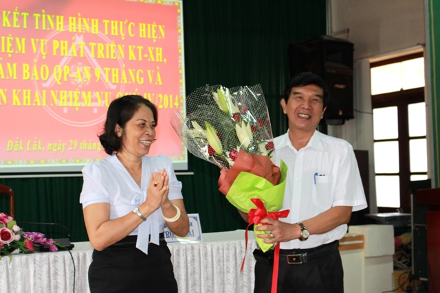 Phó Chủ tịch UBND tỉnh Mai Hoan Niê Kdăm trao hoa tặng đồng chí Hoàng Trọng Hải.
