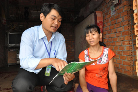Cán bộ tín dụng NHCSXH hướng dẫn thủ tục vay hộ mới thoát nghèo cho một hộ dân tại huyện Cư Kuin