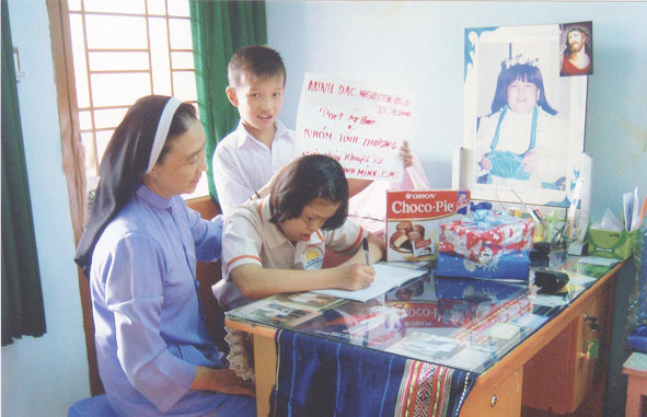 Sơ Elisabeth Lê Thị Hường, Phụ trách “gia đình Bình Minh”  hướng dẫn cháu bị bệnh down tập viết.