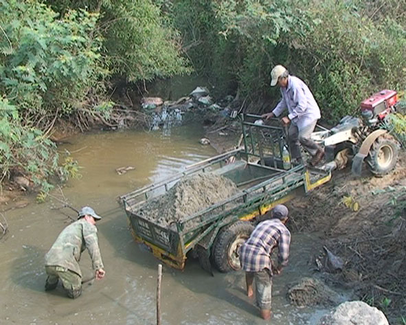 Nông dân đang nạo vét lòng suối để có nguồn nước bơm phục vụ việc gieo sạ tại cánh đồng tổ dân phố 3, thị trấn M’Đrắk. 