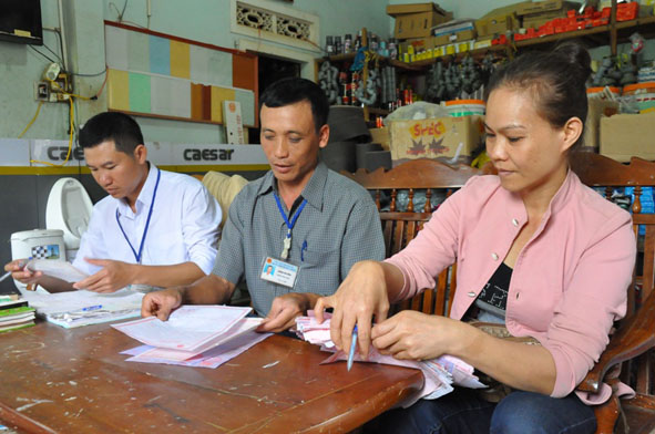 Cán bộ Chi cục Thuế huyện Cư Kuin kiểm tra chứng từ một hộ kinh doanh trên địa bàn