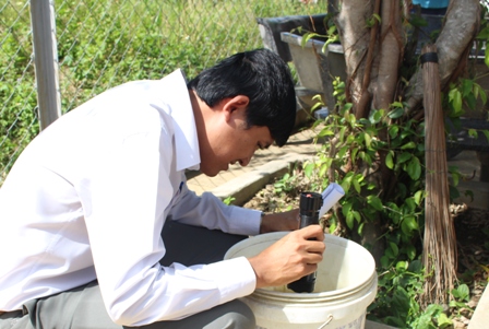 Thành viên Đoàn kiểm tra đang kiểm tra bọ gậy trong dụng cụ chứa nước tại một hộ gia đình ở thị trấn M'Drắk