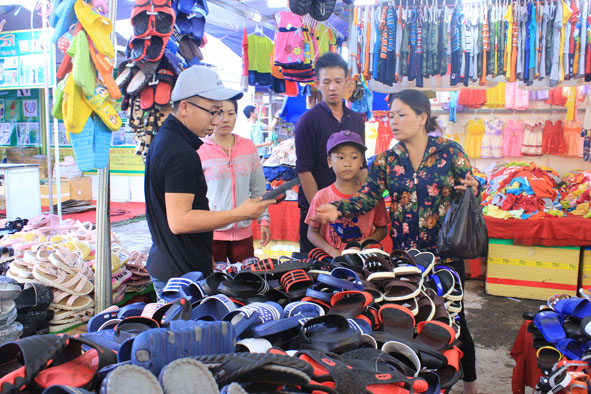 Người tiêu dùng địa phương tham quan mua sắm hàng hóa tại phiên chợ.