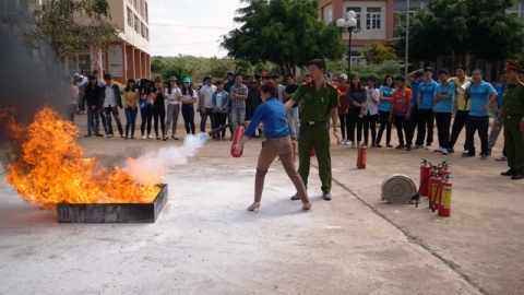 Cán bộ Phòng Cảnh sát phòng cháy và chữa cháy số 1 hướng dẫn giáo viên và học sinh trong trường cách sử dụng bình chữa cháy để dập lửa.