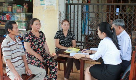 Cán bộ BHXH thị xã Buôn Hồ tuyên truyền cho người dân trên địa bàn về quyền và lợi ích khi tham gia BHYT. 