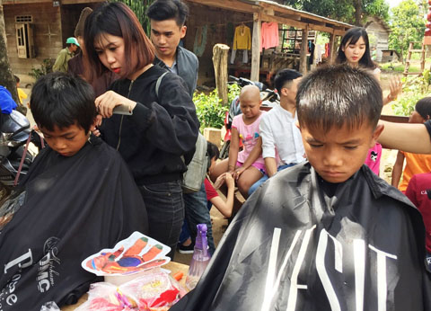 Các em nhỏ ở buôn Kuanh đang được các anh chị tình nguyện viên cắt tóc.