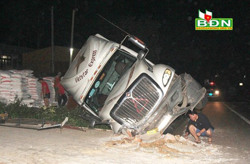 Tránh xe máy qua đường, xe container lật xuống mương nước