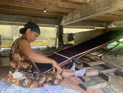Dệt thổ cẩm dưới chân nhà cộng đồng