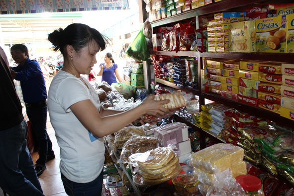 Người tiêu dùng tìm hiểu thông tin về hàng hóa trước khi chọn mua tại chợ Tân An.