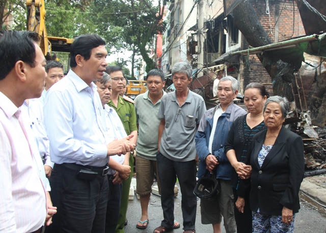 Chủ tịch UBND tỉnh Hoàng Trọng Hải (trái, áo trắng) thăm hỏi bà con nhân dân bị lửa thiêu rụi toàn bộ tài sản