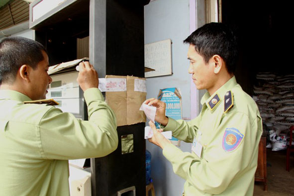 Cơ quan chức năng tiến hành niêm phong trụ bơm có gắn chíp điện tử làm sai số lượng xăng bán ra của doanh nghiệp tư nhân Tám Hòa (huyện Cư M’gar).
