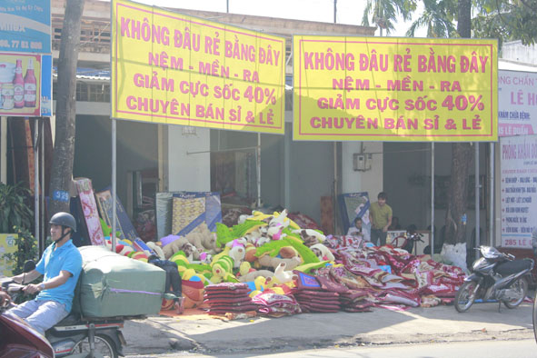 Một  cửa hàng bán  chăn nệm trên đường Lê Duẩn (TP. Buôn Ma Thuột) với những băng rôn quảng cáo  