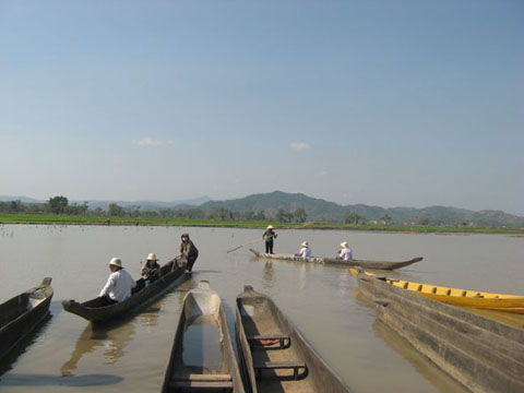 Du khách tham quan, thưởng ngoạn cảnh đẹp Hồ Lắk bằng thuyền độc mộc.