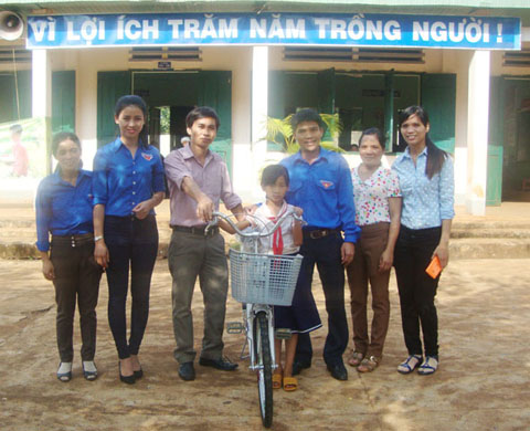 Hội đồng Đội huyện Cư M’gar cùng các thầy cô giáo trao xe cho em Đặng Thị Thảo.