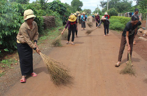 Chị em phụ nữ buôn Phơng tích cực tham gia quét dọn đường làng ngõ xóm.