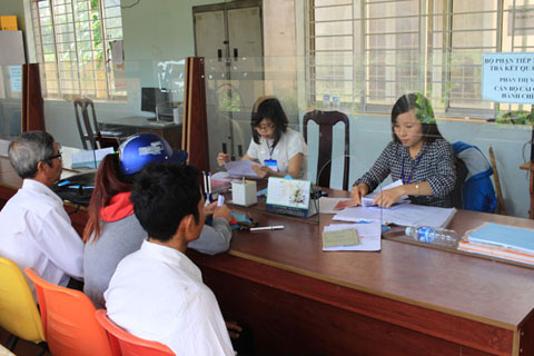 Cán bộ cải cách hành chính UBND xã Dray Bhăng (huyện Cư Kuin) tiếp nhận, xử lý hồ sơ của người dân.   Ảnh: Hoàng Gia