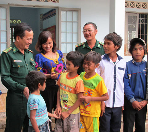 Đại tá Phạm Hữu Chiến, Chủ nhiệm Chính trị Bộ đội Biên phòng tỉnh  (ngoài cùng, bên trái) chuyện trò, động viên các em tham gia  lớp học xóa mù chữ.