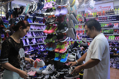 Khách chọn mua giày dép tại chợ Trung tâm Buôn Ma Thuột.