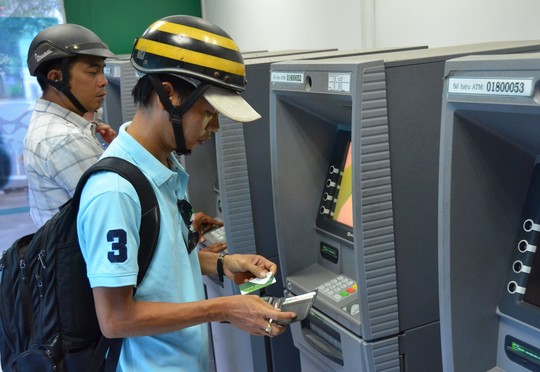 Công nhân rút tiền tại các máy ATM ở KCX Tân Thuận, TP HCM (ảnh lớn) và một máy ATM trên đường Bà Huyện Thanh Quan (quận 3) không hoạt động trong sáng 9-2 (ảnh nhỏ)Ảnh: Tấn Thạnh