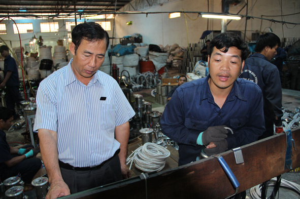 Ông Nguyễn Đăng Phong kiểm tra việc sản xuất tại xưởng. 