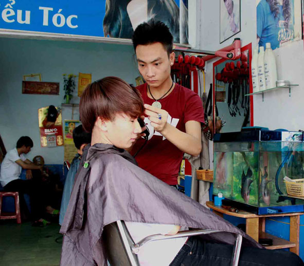 Các tay kéo tại một tiệm cắt tóc trên đường Nguyễn An Ninh (phường Ea Tam, TP. Buôn Ma Thuột) đang cắt tóc cho khách.