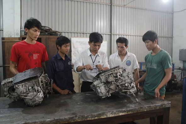 Thầy Ngô Phạm Hồng Phước (đứng giữa), Trưởng bộ môn Cơ khí -  Khoa Cơ điện xây dựng, Trường Cao đẳng Nghề Thanh niên dân tộc Tây Nguyên đang giảng bài cho các học viên.