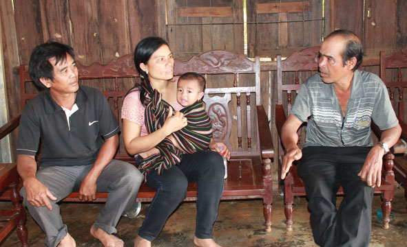 Ông Y Gua Byă (bên phải), Trưởng buôn Ea H’Luk (xã Ea Tiêu, huyện Cư Kuin) thăm hỏi gia đình có người thân đi xuất khẩu lao động.