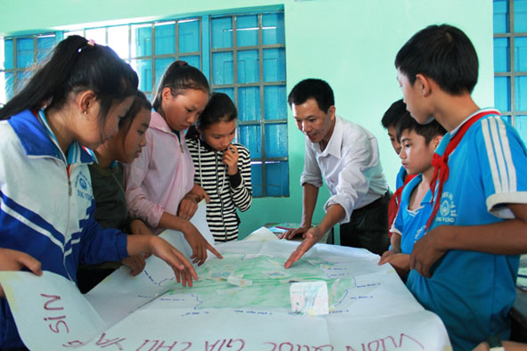 Cán bộ kiểm lâm VQG Chư Yang Sin đang giảng cho các em học sinh bằng bản đồ.