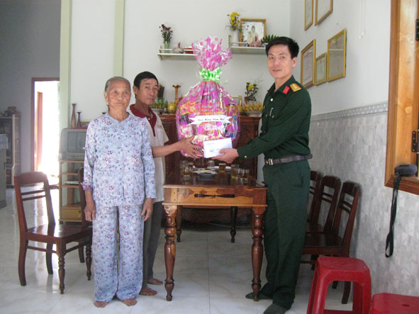 Thượng tá  Trần Minh Châu,  Chính trị viên  Ban CHQS huyện  Krông Năng thăm hỏi,  trao quà tặng Mẹ Việt Nam Anh hùng Nguyễn  Thị Bản. 