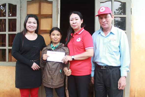 Cán bộ Hội Chữ thập đỏ huyện Ea Kar và xã Cư Ni thăm, tặng quà Tết cho gia đình chị H’Đinh Niê ở buôn Ea Knuốp.