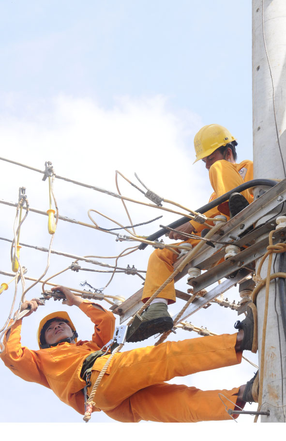 Công nhân Công ty  Điện lực  Đắk Lắk  sửa chữa lưới điện.  Ảnh: X.Vinh 