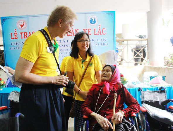 Đại diện nhà tài trợ xe lăn, xe lắc - Hội từ thiện Latter - Day Saint Charites chuyện trò, động viên người khuyết tật.
