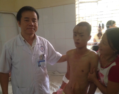 Bác sỹ chuyên khoa 2 Văn Hữu Khánh (bìa trái) thăm khám bệnh nhân Thành trước khi xuất viện