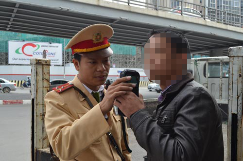 Cảnh sát giao thông Hà Nội kiểm tra nồng độ cồn của một tài xế Ảnh: NGUYỄN HƯỞNG
