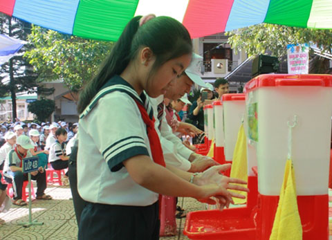 Các em học sinh và đại biểu thực hành rửa tay bằng xà phòng.