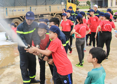Cảnh sát PCCC hướng dẫn các em thiếu nhi sử dụng lăng vòi trong chương trình trải nghiệm “Một ngày làm lính cứu hỏa”. 