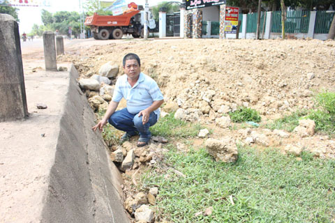 Ông Phan Xuân Nam bên thửa đất đang đề nghị thu hồi do nước từ hồ trung chuyển thị trấn Ea Súp chảy tràn vào.