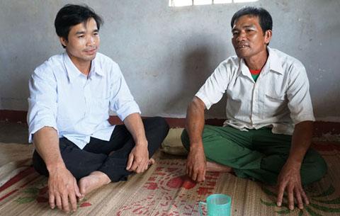 Trưởng thôn Dhung Knung Nguyễn Xuân Biển (bìa phải) trao đổi cùng công an viên của thôn về tình hình nghiện hút trên địa bàn.