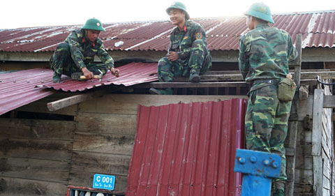 Bộ đội giúp người dân xã Yang Mao dựng lại nhà cửa sau bão.