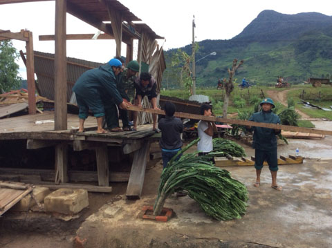 Lực lượng vũ trang huyện Krông Bông giúp bà con xã Yang Mao khắc phục hậu quả sau bão. Ảnh: Trần Hưng