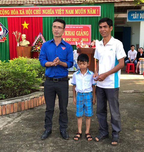 Anh Huỳnh Văn Thảo (bên trái) đại diện Đoàn xã Cư Huê tặng quà  cho học sinh nghèo vượt khó học giỏi trên địa bàn.
