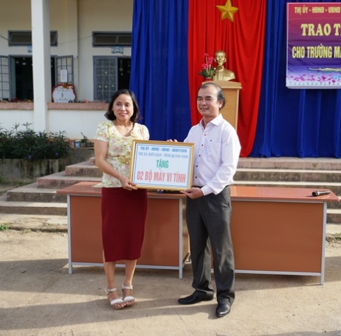 Đại diện Thị ủy - HĐND – UBMTTQ thị xã Điện Bàn, tỉnh Quảng Nam trao máy vi tính cho hiệu trưởng trường mẫu giáo Cư Pui.