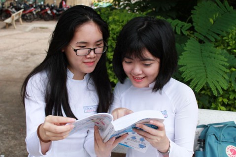Em Võ Thị Cúc Phương (bìa phải) thường xuyên trao đổi bài với bạn trong giờ giải lao. 