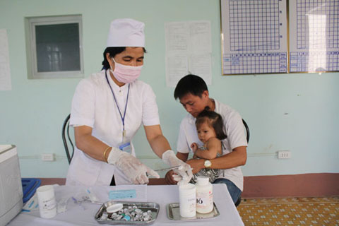 Chị H’Đrao Knul, cán bộ y tế xã Ea Wer tiêm phòng cho trẻ em.    