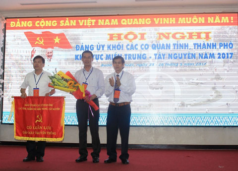Bí thư Đảng ủy Khối Các cơ quan tỉnh Đắk Lắk Trần Đình Quế (bên phải) trao cờ luân lưu tổ chức hội nghị cho Đảng ủy Khối Các cơ quan tỉnh Thanh Hóa. 