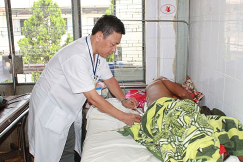 Bác sĩ Huỳnh Như Đồng kiểm tra vết thương của bệnh nhân Y Sơn sau phẫu thuật.