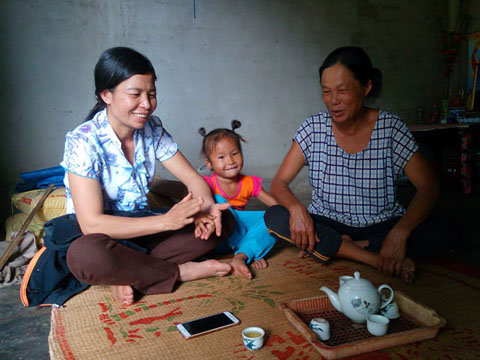 Cán bộ Hội Phụ nữ xã Ea Wer đến thăm gia đình bà Nông Thị Nhung (phải) có hai con đi xuất khẩu lao động tại Ảrập Xêút. 