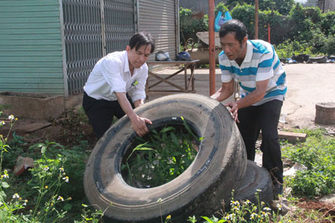 Cán bộ phường  Tân Lợi  (TP. Buôn  Ma Thuột) đổ nước đọng  trong lốp xe ngăn ngừa muỗi  phát sinh.  