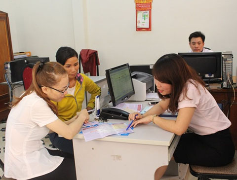Nhân viên đại lý thu BHYT xã Hòa Xuân (TP. Buôn Ma Thuột) tư vấn mức tham gia BHYT cho người dân. 